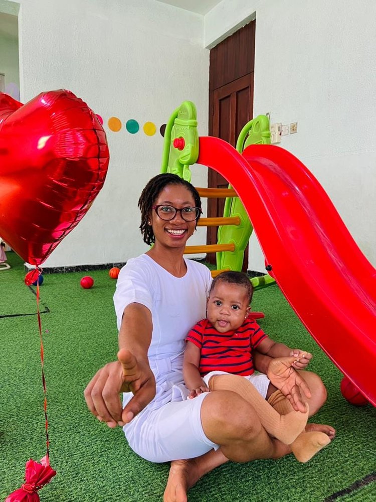 A baby with a caregiver at Flourish Playhouse crèche in Festac Town